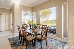 La Quinta house for rent - A dining room with a table and chairs and a view of a lawn outside.
