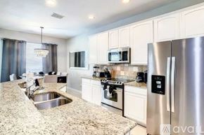 Kissimmee house for rent - A kitchen with granite countertops and stainless steel appliances.