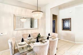 Kissimmee house for rent - A modern dining room with a glass table and chairs.