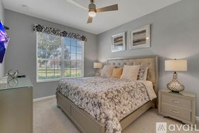 Kissimmee house for rent - A bedroom with a large bed and a ceiling fan.