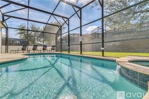 Kissimmee house for rent - A pool inside a glass enclosure with sunlight shining through.