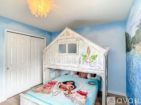 Kissimmee house for rent - A child's bedroom with a white bed and a blue wallpapered wall.