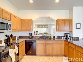Kissimmee house for rent - A kitchen with wooden cabinets and a black dishwasher.