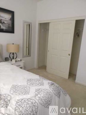 San Leandro house for rent - A bedroom with a bed, nightstand, lamp, and a painting on the wall.