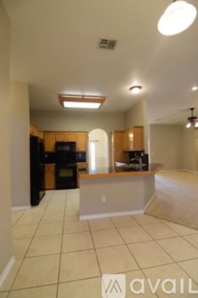 Harker Heights house for rent - A spacious room with a chandelier, arched doorways, and a view of a garden through the windows.