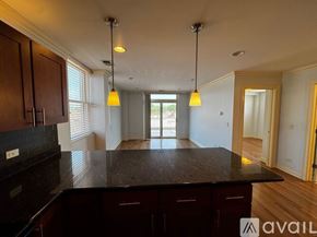 Chicago apartment for rent - A spacious room with wooden flooring and a bar area in the corner.