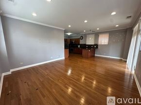 Chicago apartment for rent - A room with wooden floors and a sliding glass door leading to a balcony.