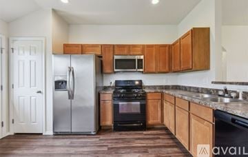 Bixby house for rent - A kitchen with wooden cabinets and a stainless steel refrigerator.
