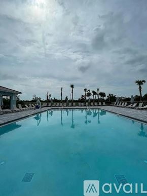 Port Charlotte house for rent - A large outdoor swimming pool with a cloudy sky in the background.