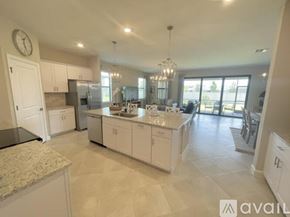 Port Charlotte house for rent - A spacious kitchen with white cabinets and a marble countertop.