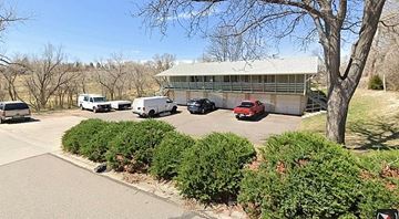 Lakewood apartment for rent - A parking lot with a building and cars.