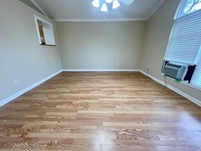 Oldham house for rent - A room with wooden flooring and a window with blinds.