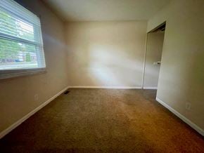 Oldham house for rent - A room with a carpeted floor and a window.