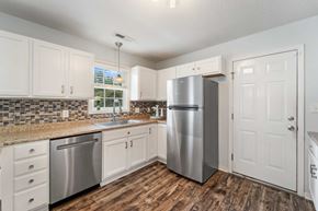 Jacksonville house for rent - A kitchen with a stainless steel refrigerator and wooden floors.