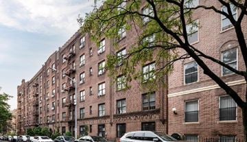 Brooklyn apartment for rent - A row of red brick apartment buildings with cars parked in front.