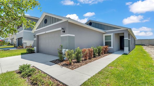 Auburndale house for rent - A modern house with a grey exterior and a white garage door.