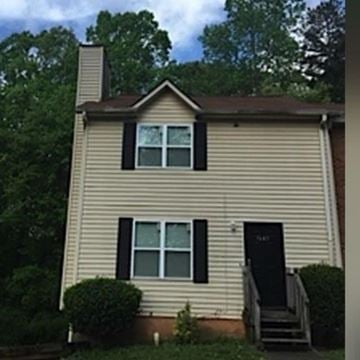 Atlanta house for rent - A house with a black door and a small porch.
