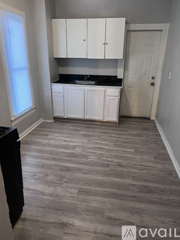 Warren house for rent - A kitchen with white cabinets and a black countertop.