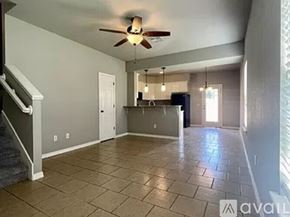 Siloam Springs townhouse for rent - A spacious living room with a ceiling fan and tiled flooring.