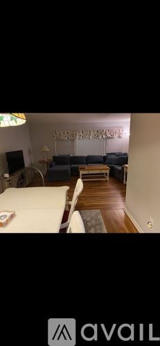 Bradley Beach house for rent - A living room with a white couch and a wooden floor.
