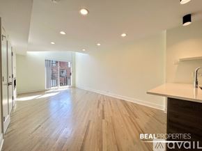 Chicago condo for rent - A spacious room with a kitchen island and wooden flooring.