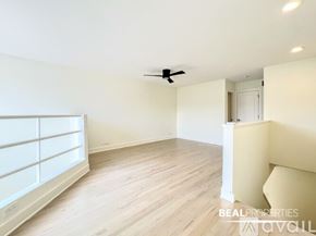 Chicago condo for rent - A spacious room with a ceiling fan and light fixture.