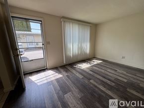 Salem apartment for rent - A room with wooden flooring and a sliding glass door leading to a balcony.