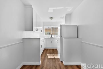 Los Angeles apartment for rent - A kitchen with white cabinets and a white fridge.