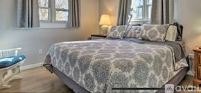Boone house for rent - A bedroom with a large bed and a blue chair.