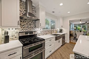 Savannah house for rent - A kitchen with a stove top oven and a hood.