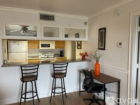 Fort Myers condo for rent - A black chair is in front of a table with a yellow vase on it.