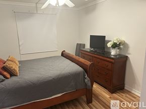 Fort Myers condo for rent - A bedroom with a bed, a dresser with a television and a whiteboard on the wall.