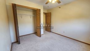 Rochester apartment for rent - A bedroom with a carpeted floor and a ceiling fan.