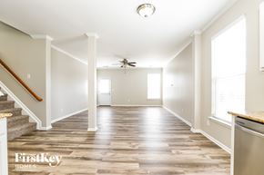 Burlington house for rent - A spacious room with wooden flooring and a staircase leading to the upper level.