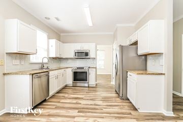 Burlington house for rent - A kitchen with white cabinets and stainless steel appliances.