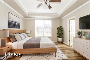 Burlington house for rent - A bedroom with a bed, a ceiling fan, and a window.