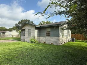 El Campo house for rent - A house with a grey roof and a grey wall with a window and a door.