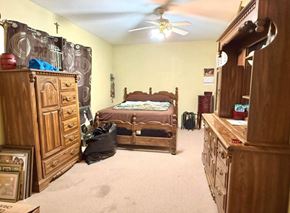 El Campo house for rent - A bedroom with a bed, dresser, and ceiling fan.