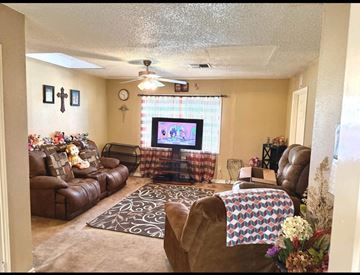 El Campo house for rent - A living room with a brown leather couch and a television on the wall.