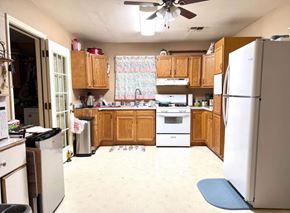 El Campo house for rent - A kitchen with a white refrigerator, white stove, and wooden cabinets.