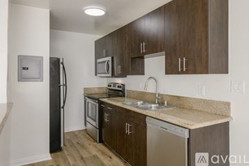 Los Angeles apartment for rent - A kitchen with brown cabinets and a black refrigerator.