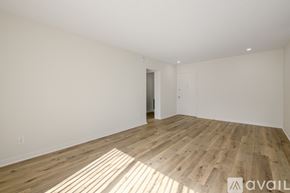 Los Angeles apartment for rent - A spacious room with wooden flooring and white walls.
