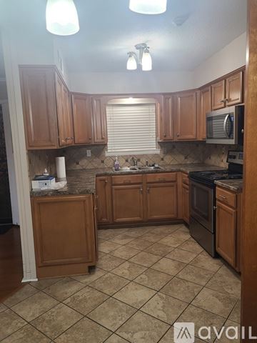 Memphis house for rent - A kitchen with wooden cabinets and a tile floor.