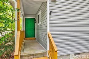 Raleigh house for rent - A house with a green door and a wooden staircase leading to the entrance.