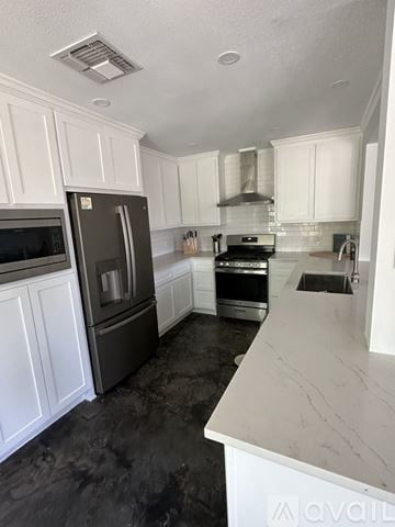 Austin house for rent - A kitchen with white cabinets and a marble counter.