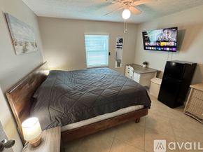 Port St. Lucie house for rent - A bedroom with a bed, a television, and a window.