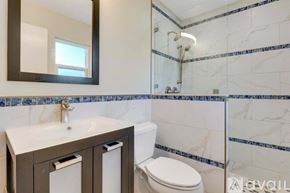 Port St. Lucie house for rent - A bathroom with a toilet, sink, and mirror.
