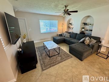Port St. Lucie house for rent - A living room with a grey couch and a black television.