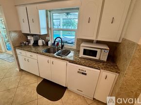 Port St. Lucie house for rent - A kitchen with white cabinets and a granite countertop.