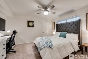 Dallas house for rent - A bedroom with a large bed and a ceiling fan.